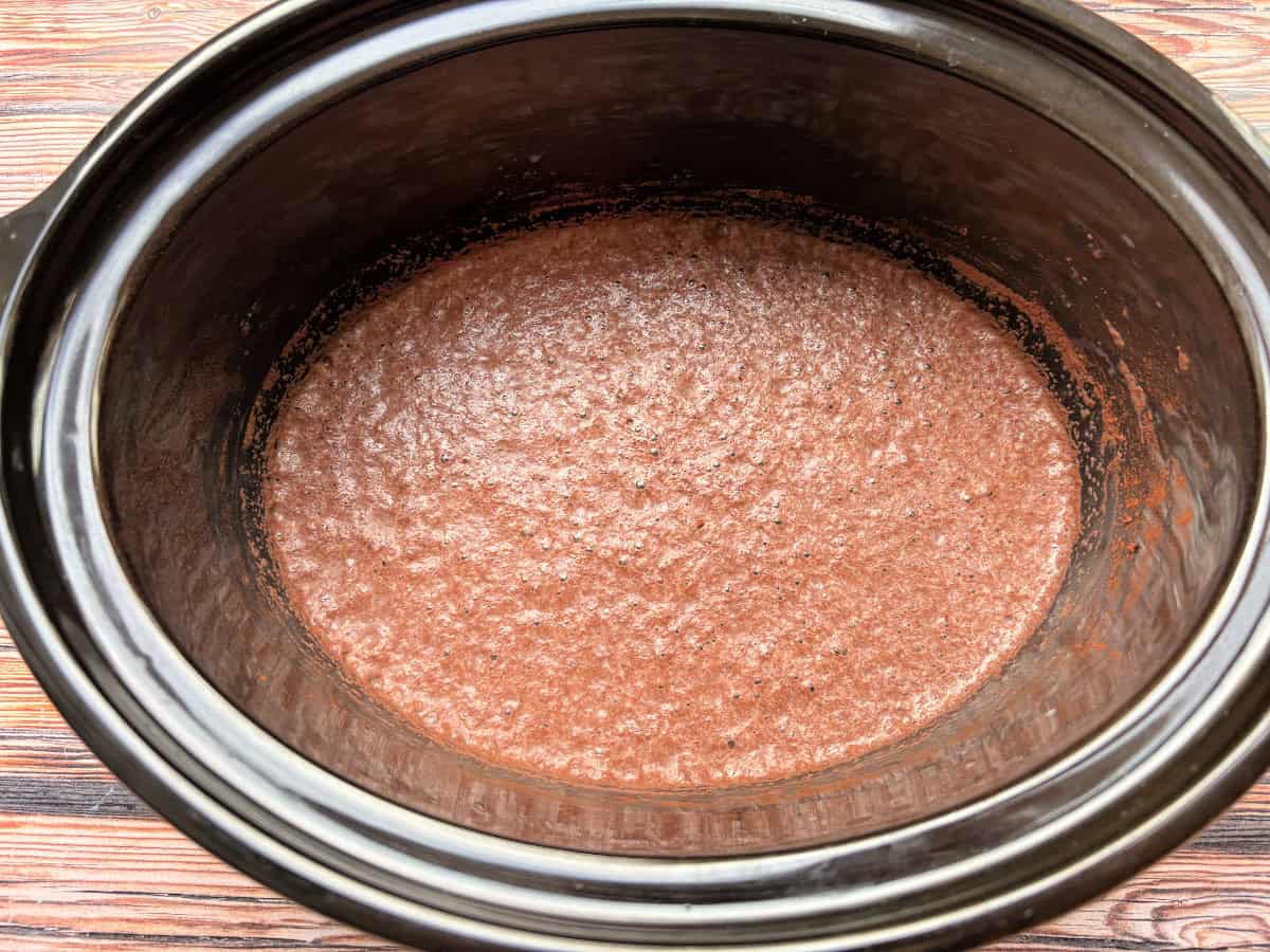 Whisked milk and cocoa powder in slow cooker pot.