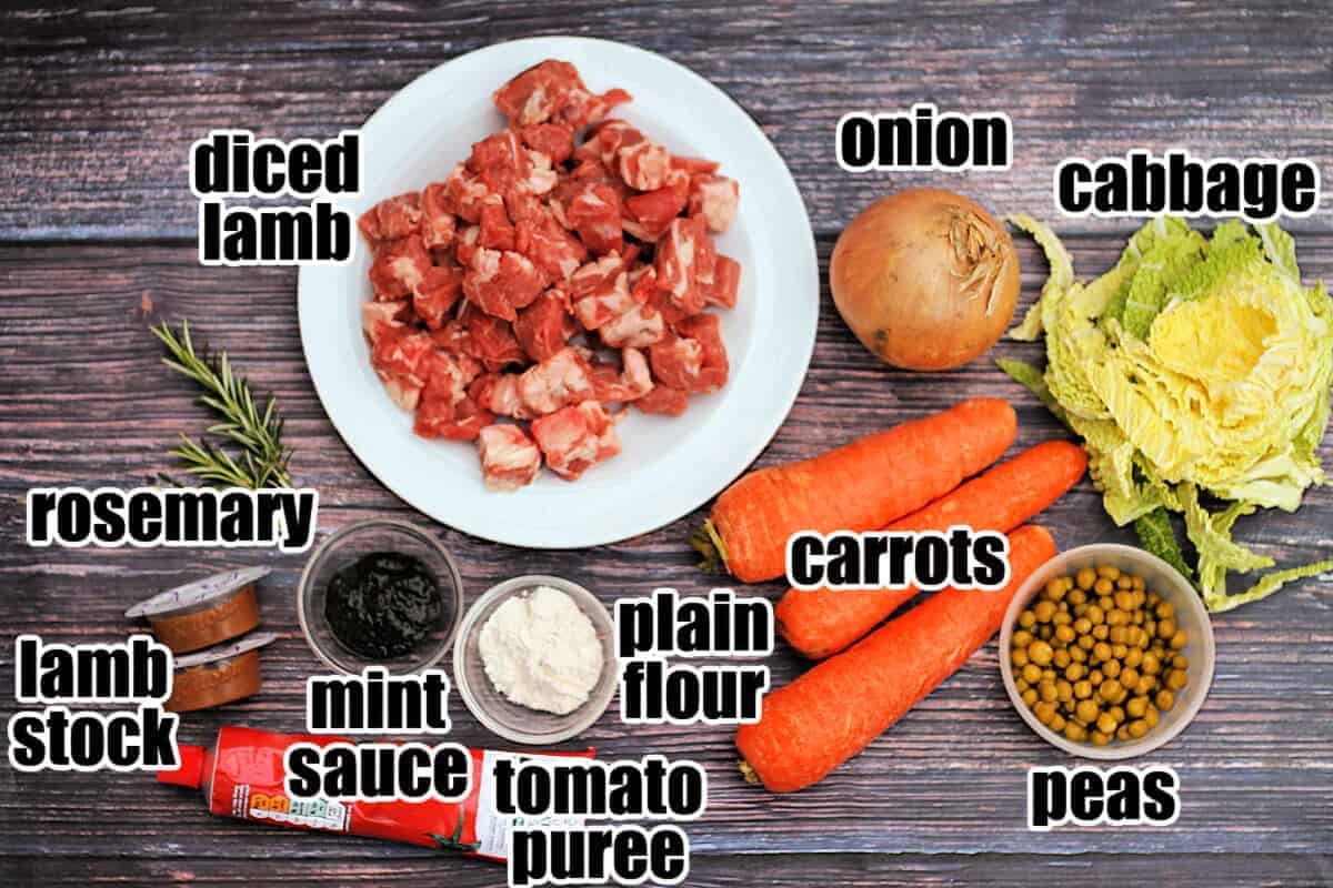 Labelled ingredients for lamb stew on wooden table.