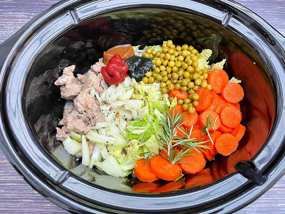 Ingredients for lamb casserole in slow cooker pot.