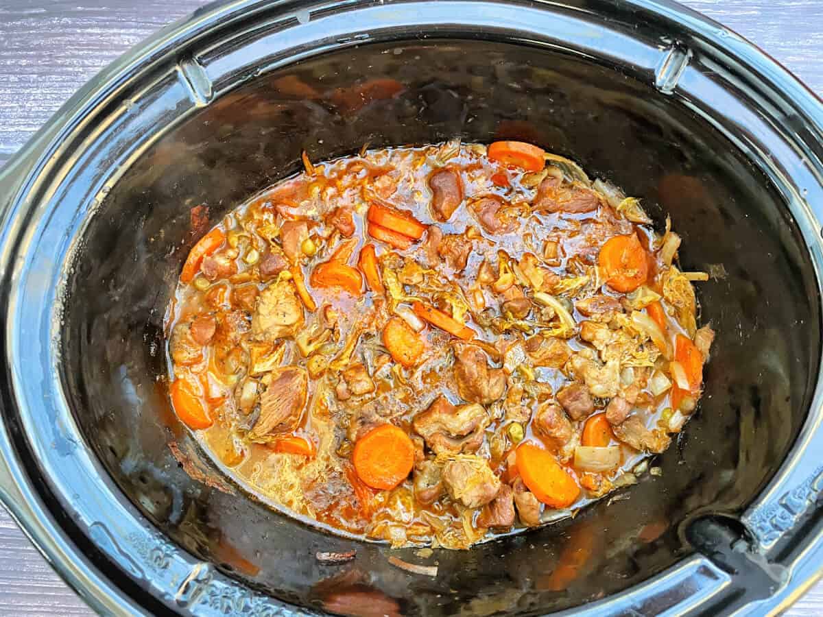 Cooked lamb stew in slow cooker pot, ready to serve.