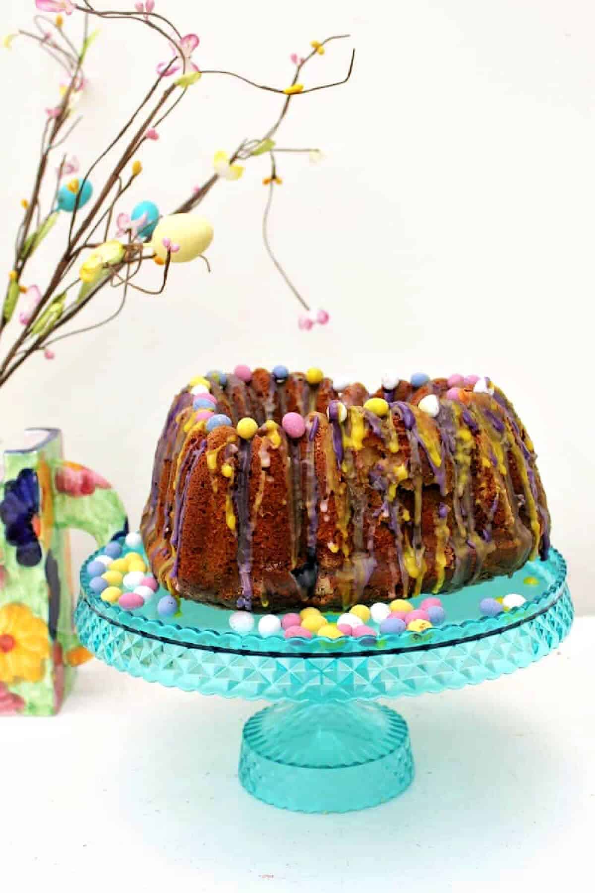 Bundt cake on cake stand with Easter decoration.