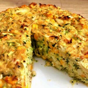 Courgette bake on a white plate, large slice cut out.