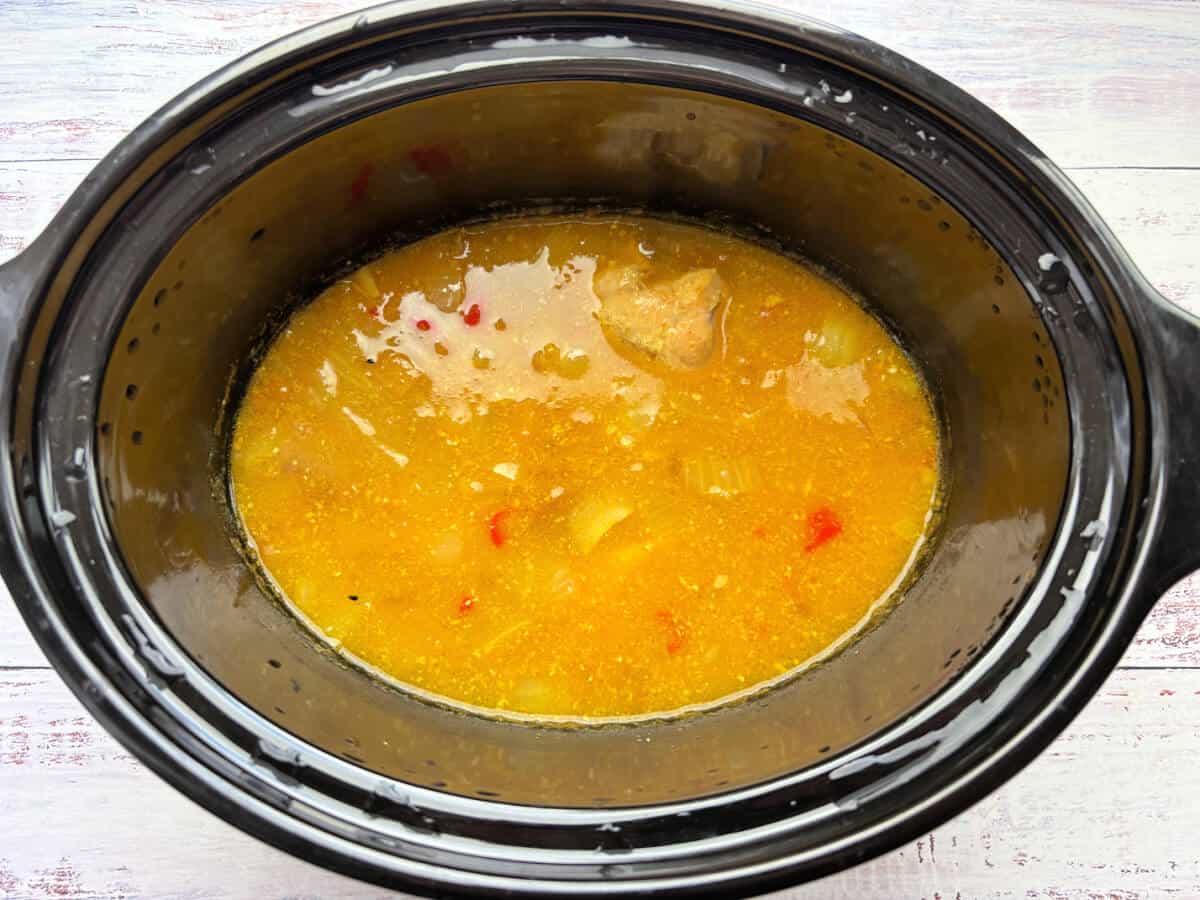 Cooked mango chicken in a slow cooker pot.
