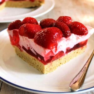 Slice of strawberry mousse cake on white plate.