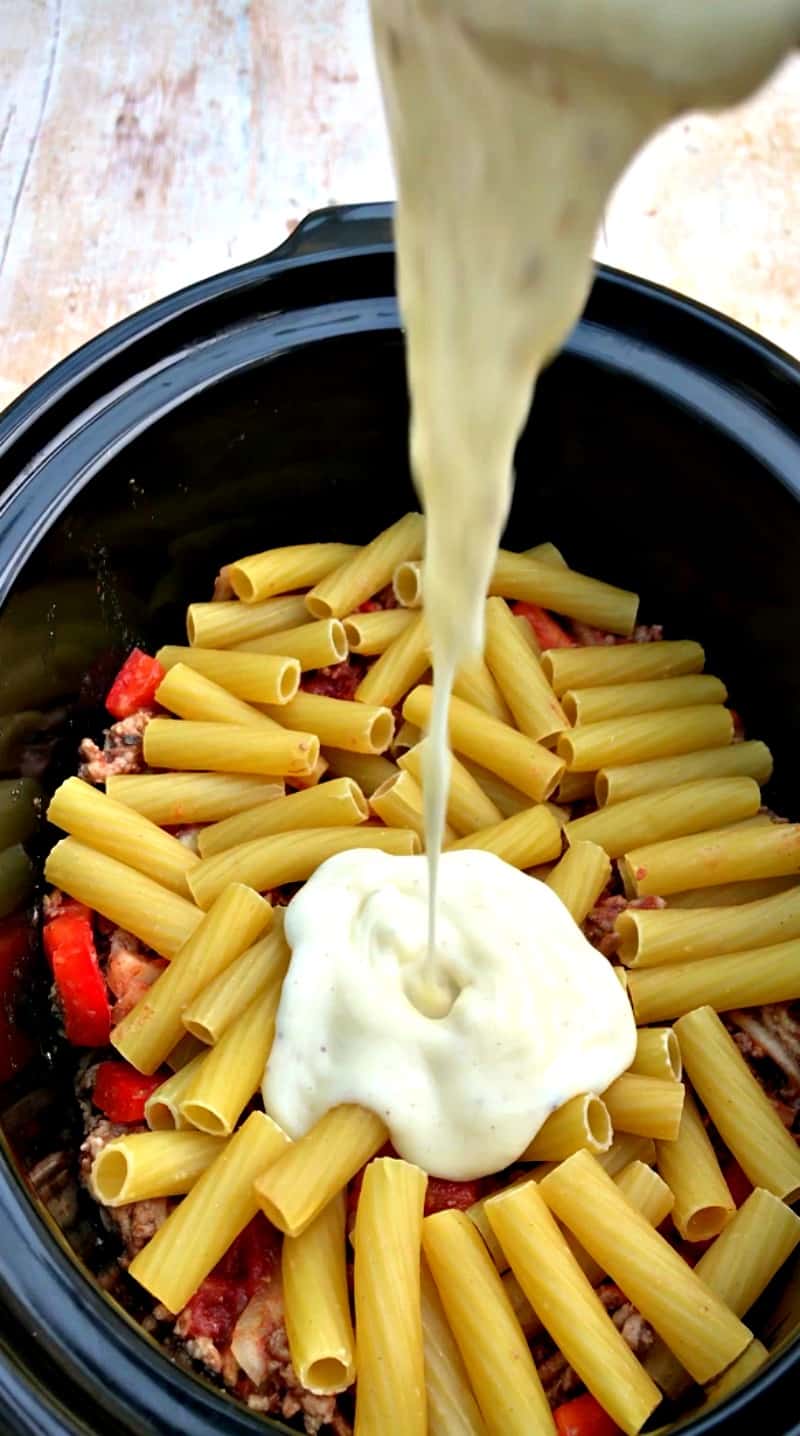 Assembling slow cooker pastitsio - adding the béchamel sauce