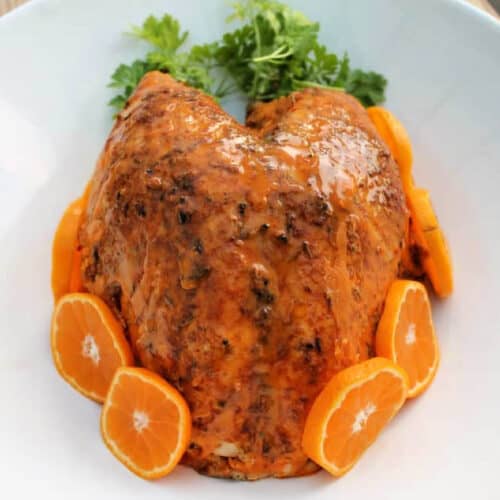 Turkey crown with glaze garnished with orange and herbs,