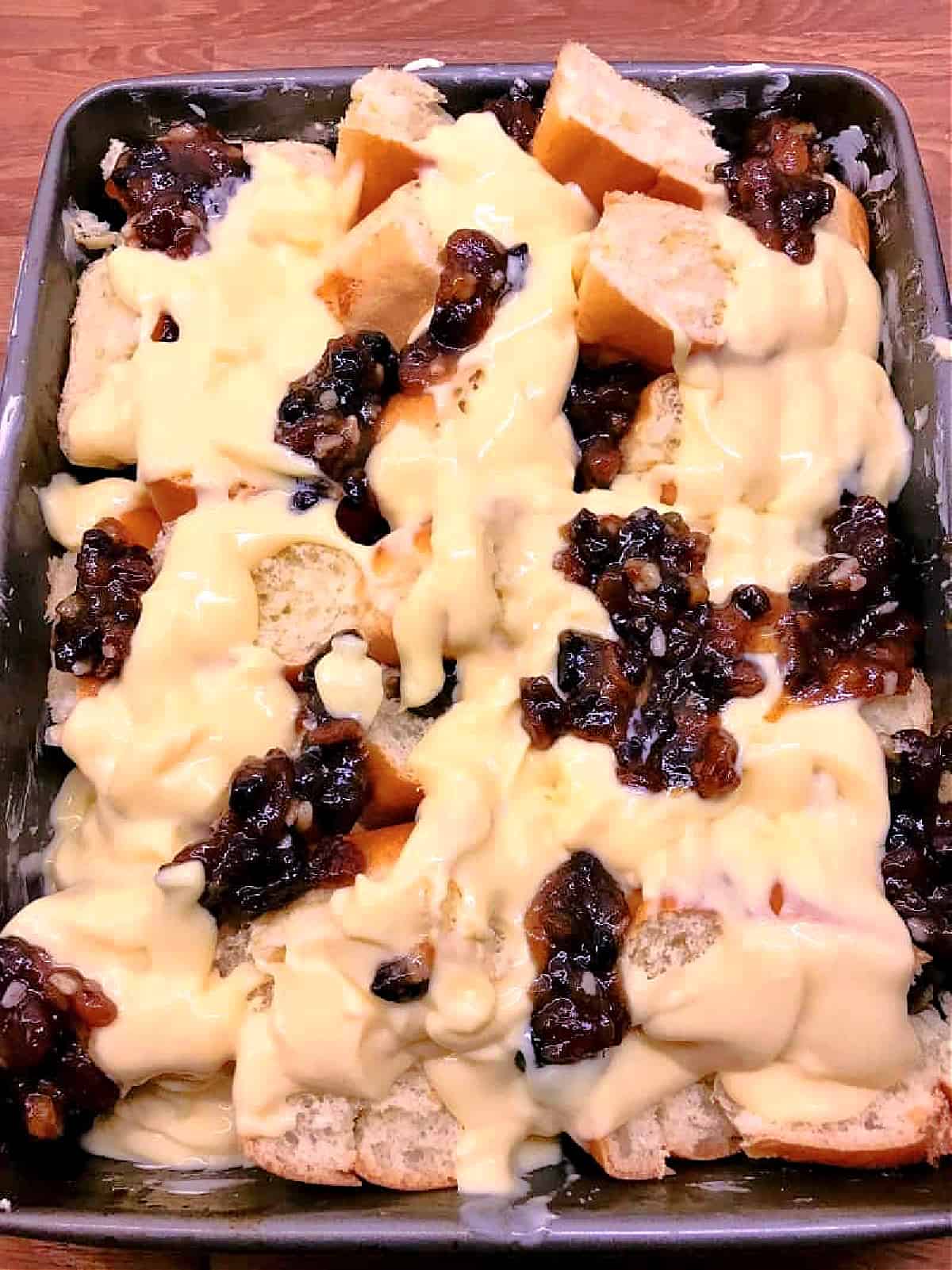 Brioche and mincemeat with custard in an oven dish, before baking.