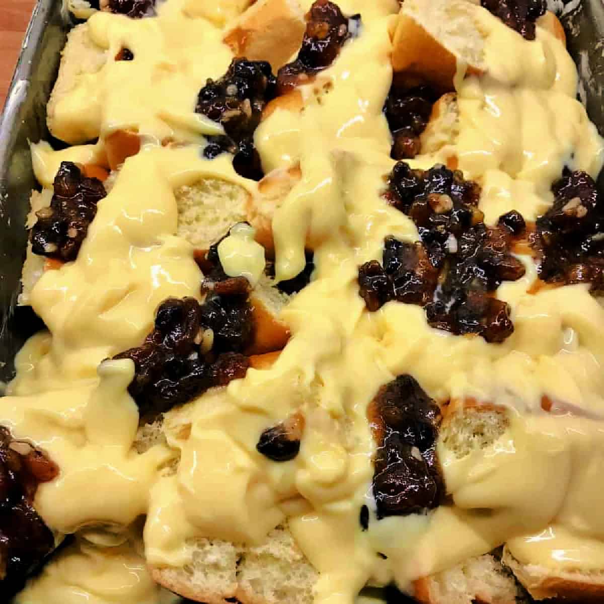 Brioche and mincemeat with custard in an oven dish, before baking.