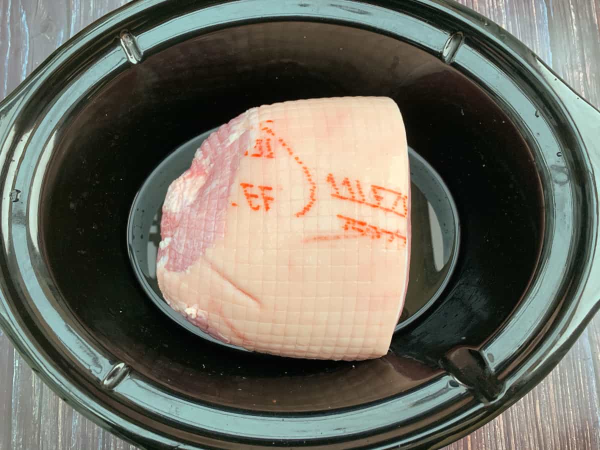 Raw gammon joint in slow cooker pot.