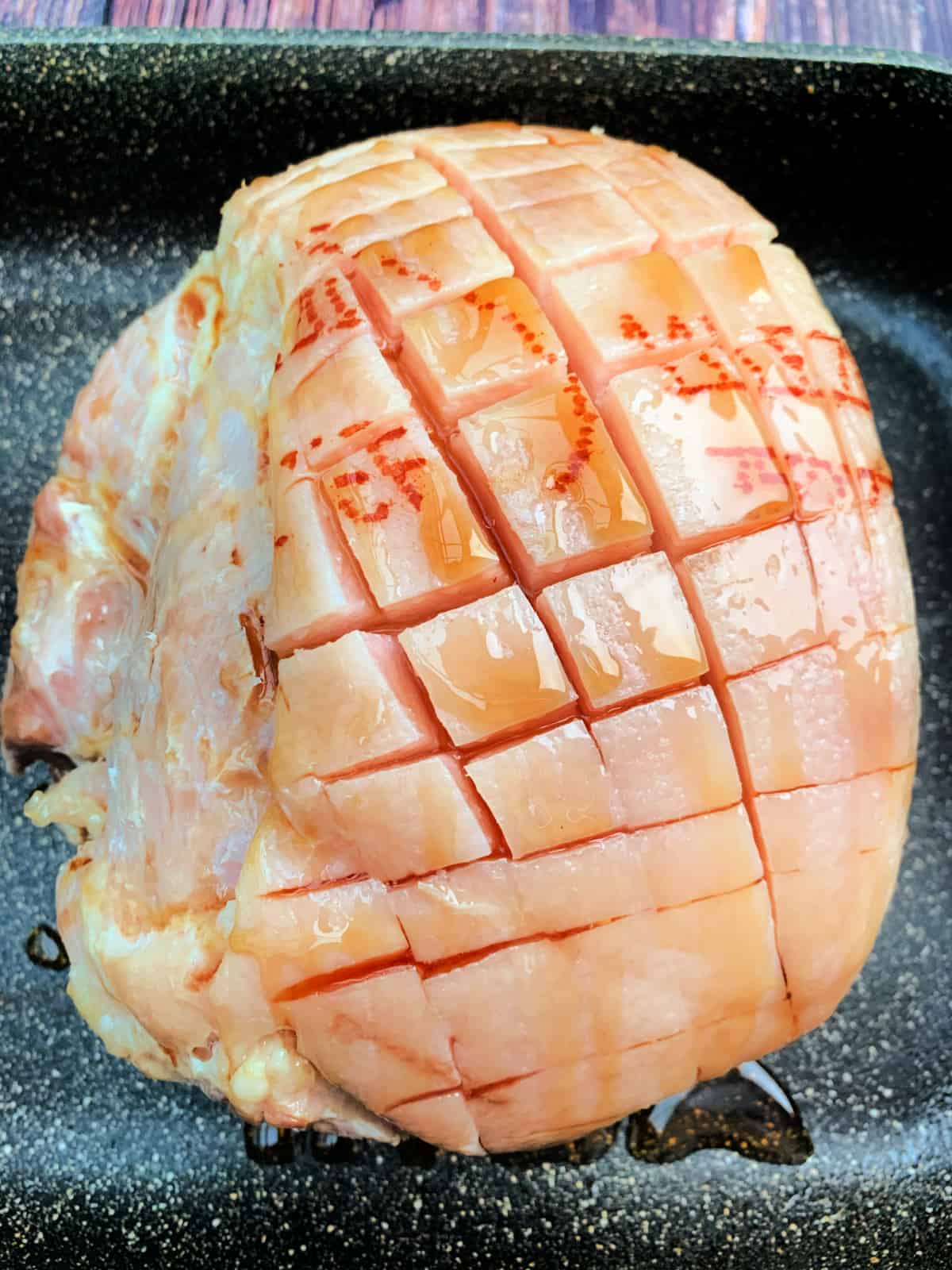 Gammon drizzled with maple syrup, before roasting.