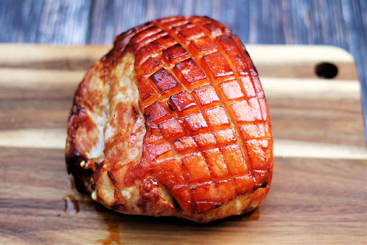 Roast gammon after cooking resting on a chopping board.