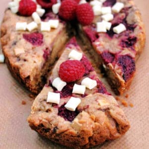 Cookie topped with raspberries and white chocolate chunks.