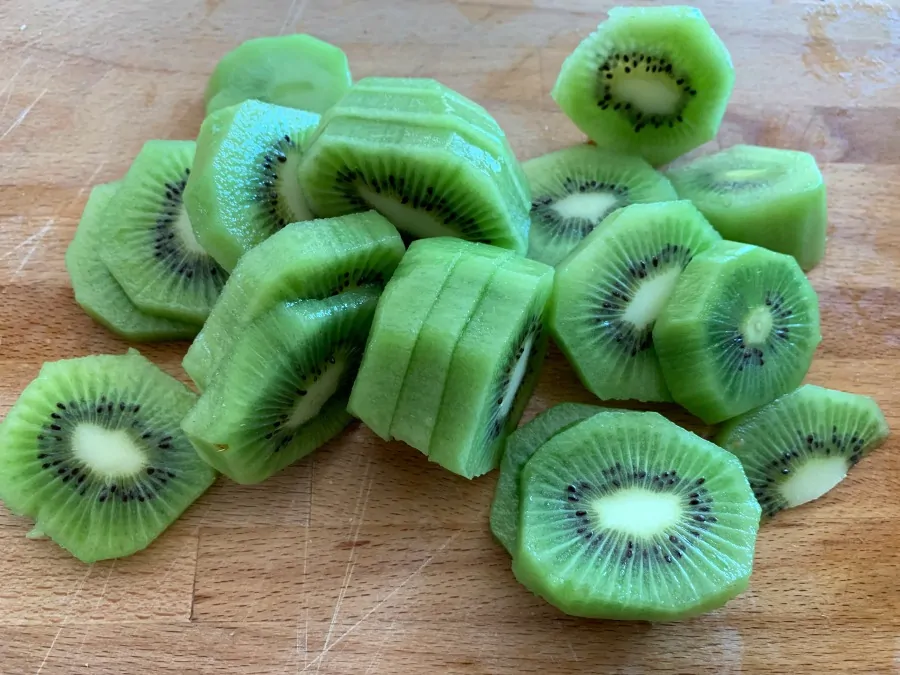 Sliced kiwi fruit on a chopping board.