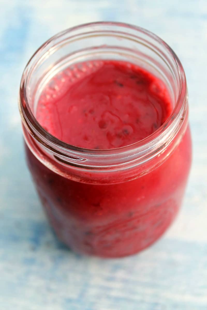 Close up from above of a jar filled with a bright berry smoothie.