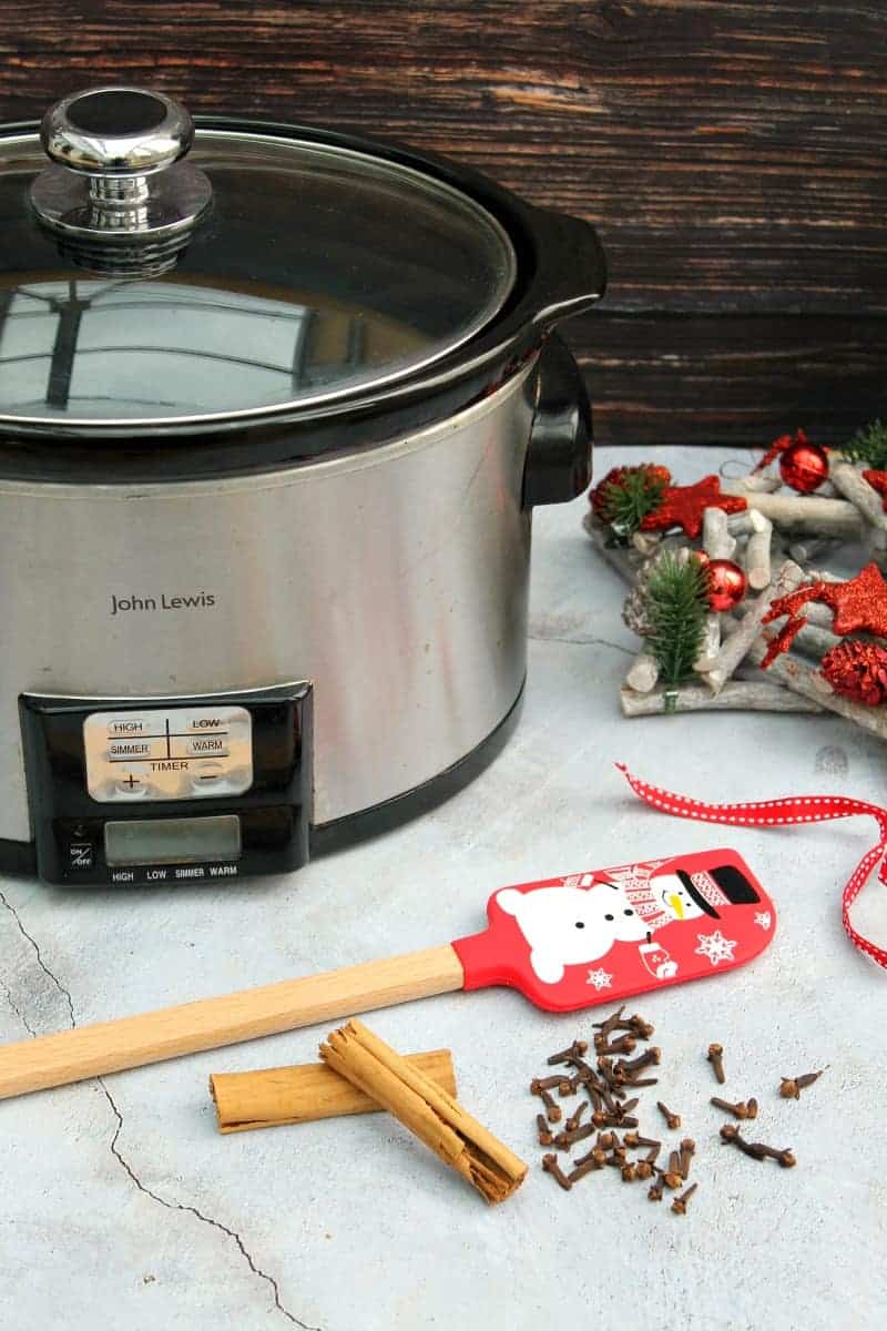 Slow cooker surrounded by Christmassy decorations.