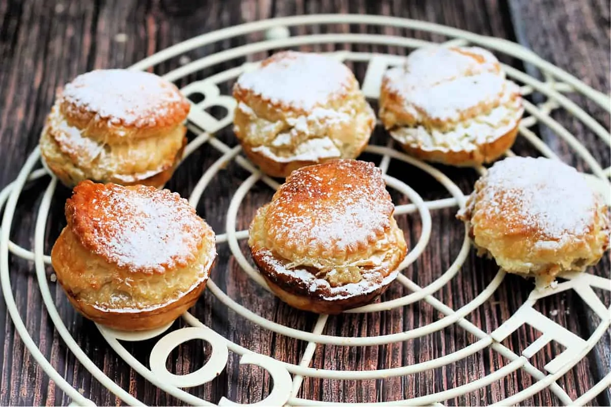 Mince pies made with puff pastry on a cooling rack.
