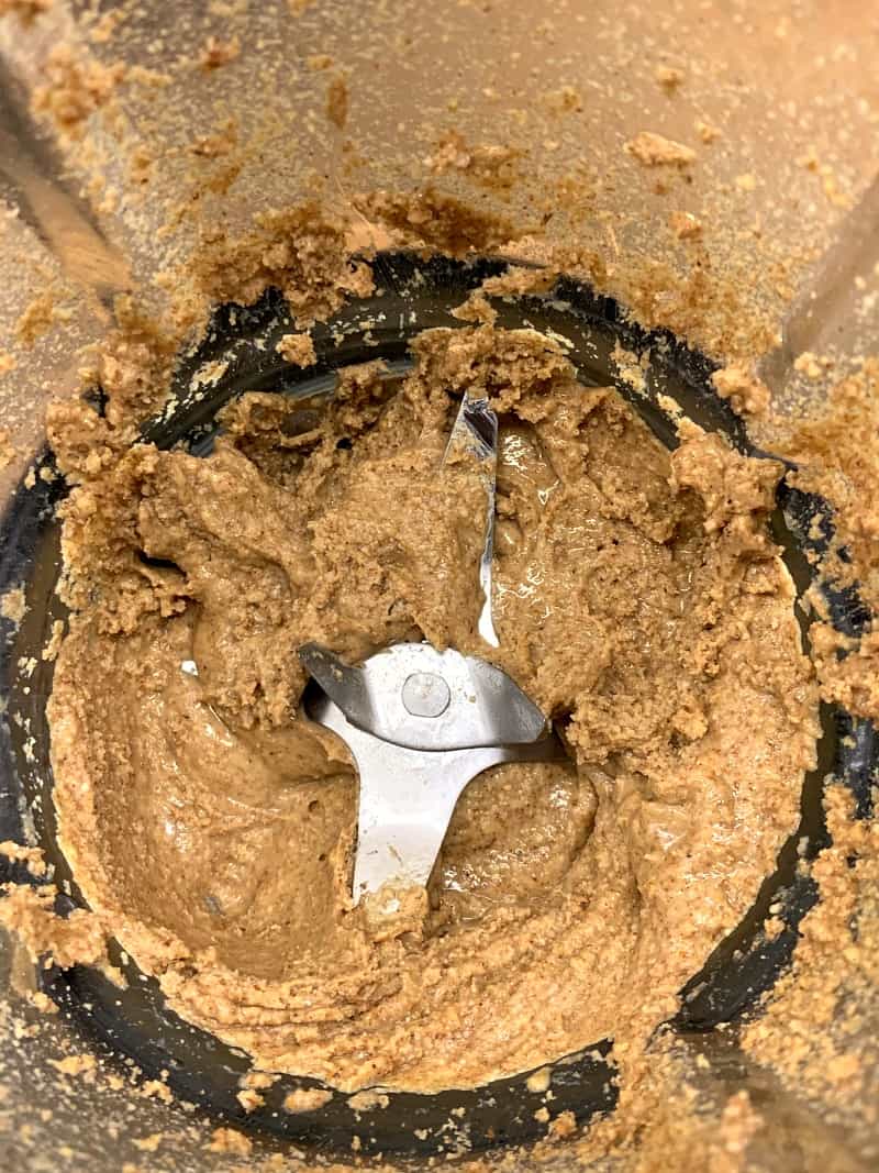 Making almond butter in a blender, inside view.