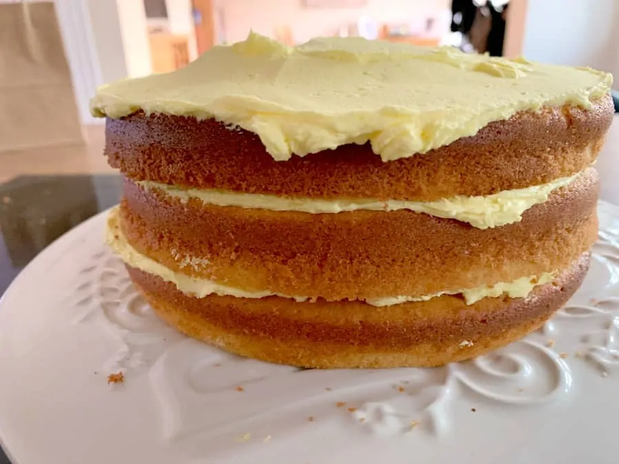 Three layers of cake with first layers of buttercream on top of each layer.