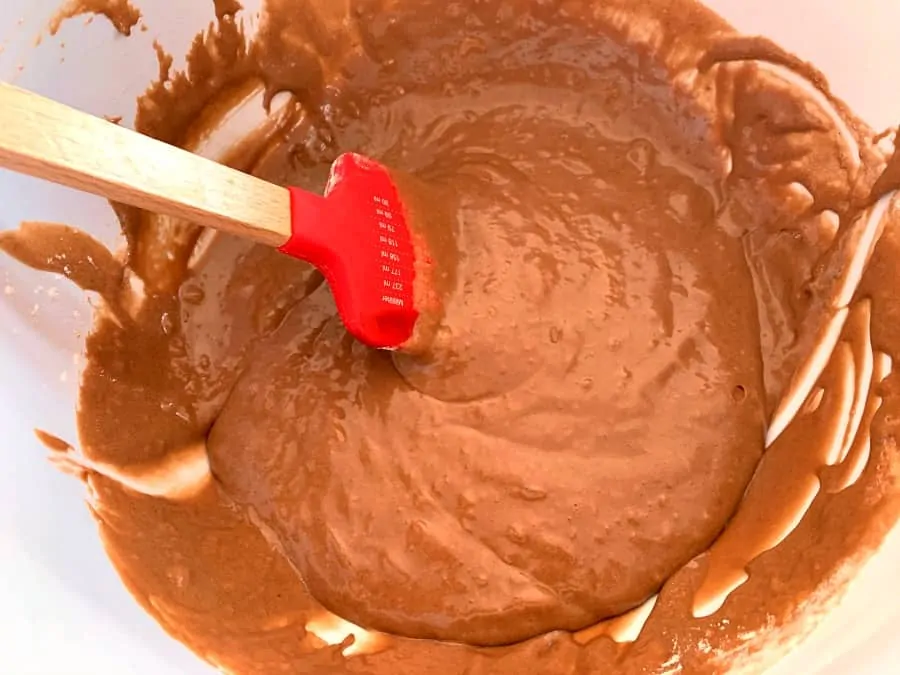 Brownie mixture after adding flour, in a white bowl.