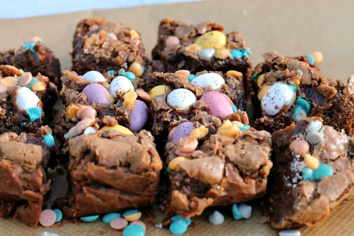 Close up of brownies with pastel chocolate eggs.
