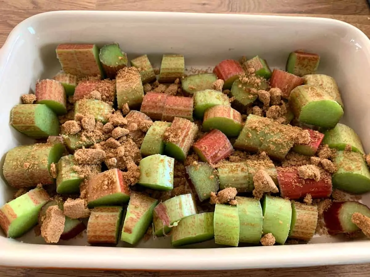 A dish of chopped rhubarb and brown sugar, ready to cook.