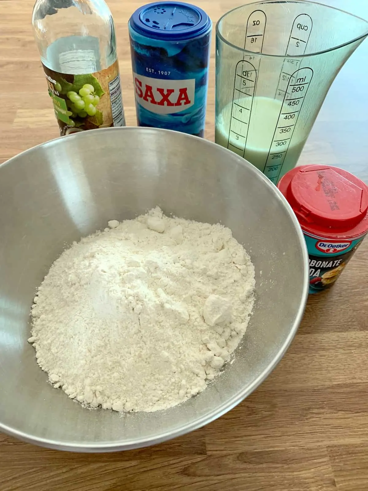 Ingredients for soda bread, bowl of flour, vinegar, salt, milk, bicarbonate of soda.
