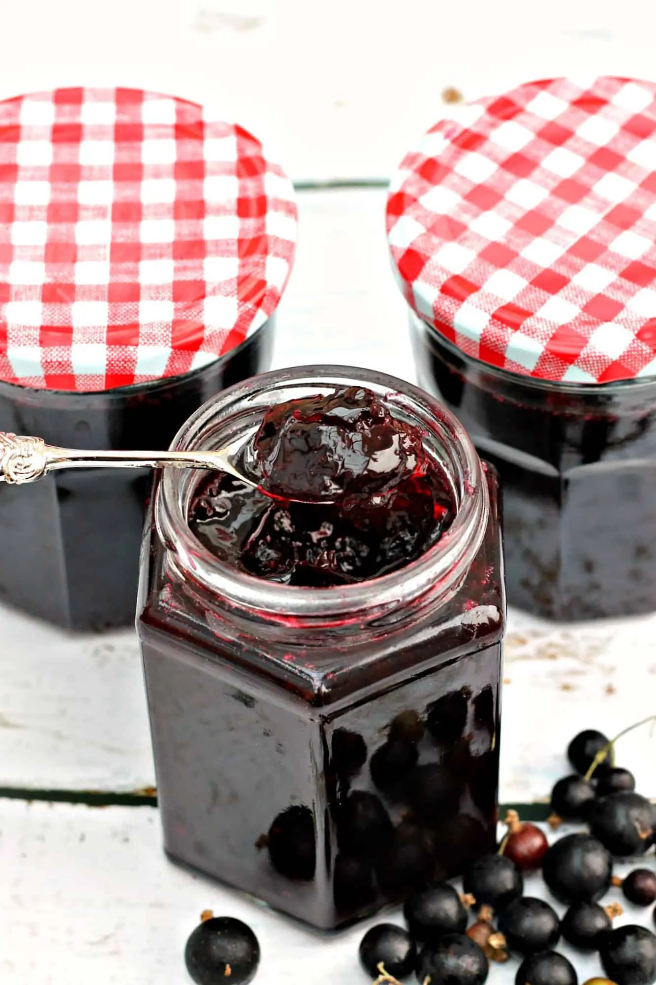 Jar of jam with a spoon of jam above, showing the perfect set.