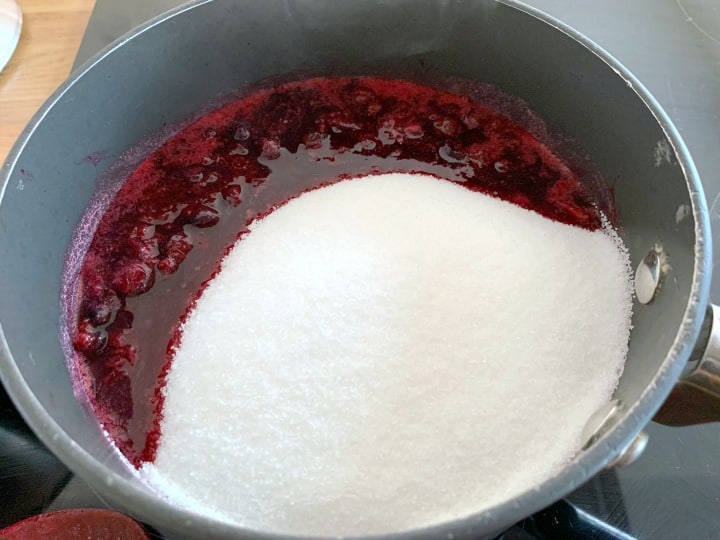 Saucepan with blackcurrants and sugar added.