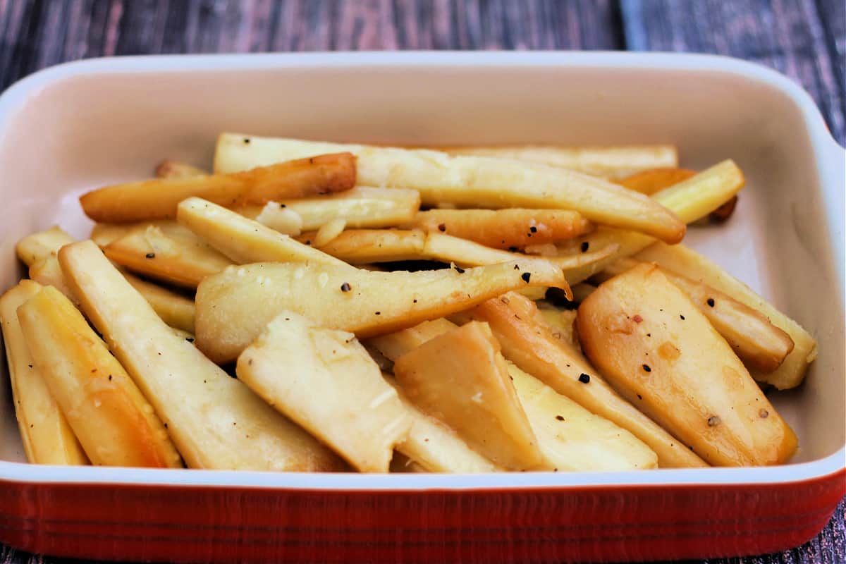 Serving dish with roast parsnips.