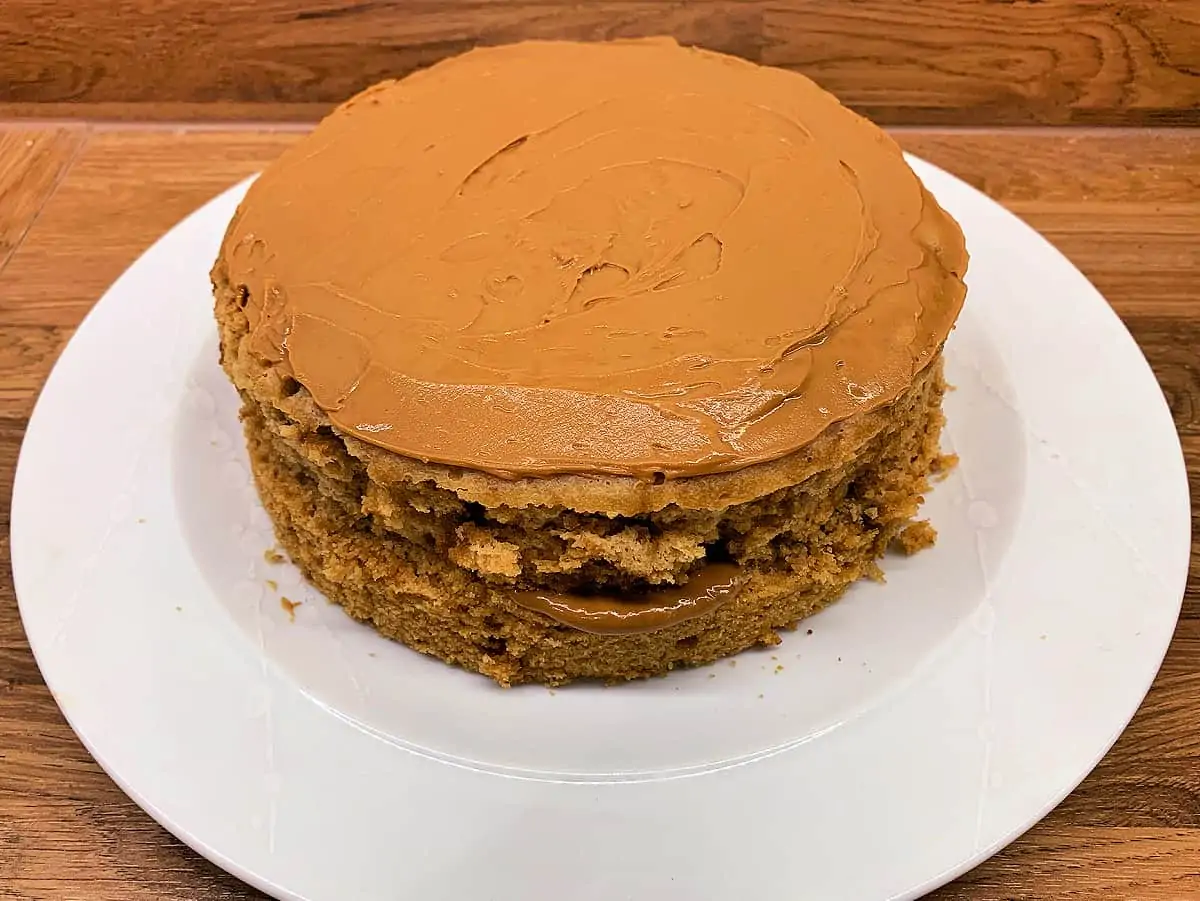 Slow cooker cake iced and filled with Biscoff spread.