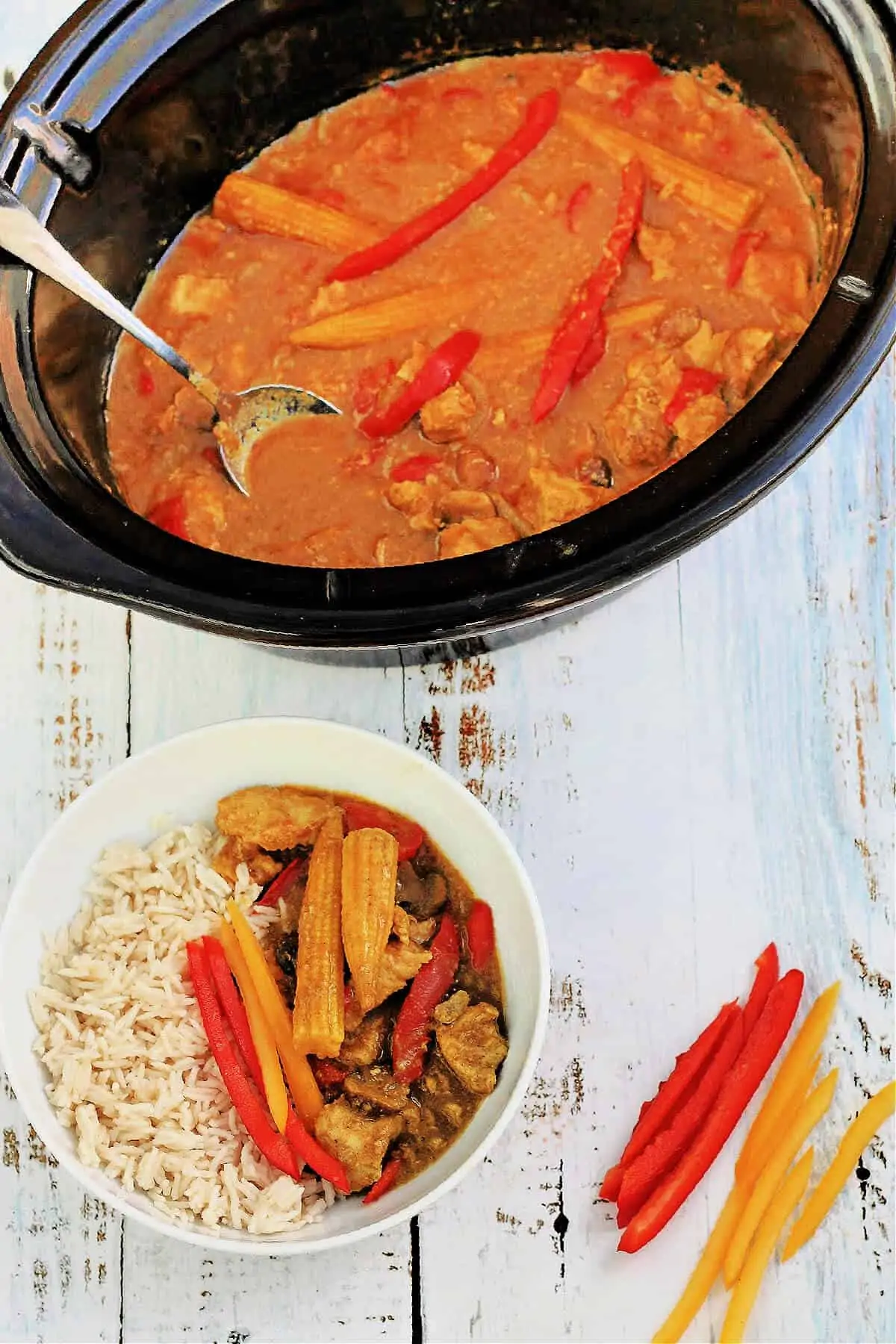 Slow cooker pot serving out Chinese curry with a bowl of curry and rice below.