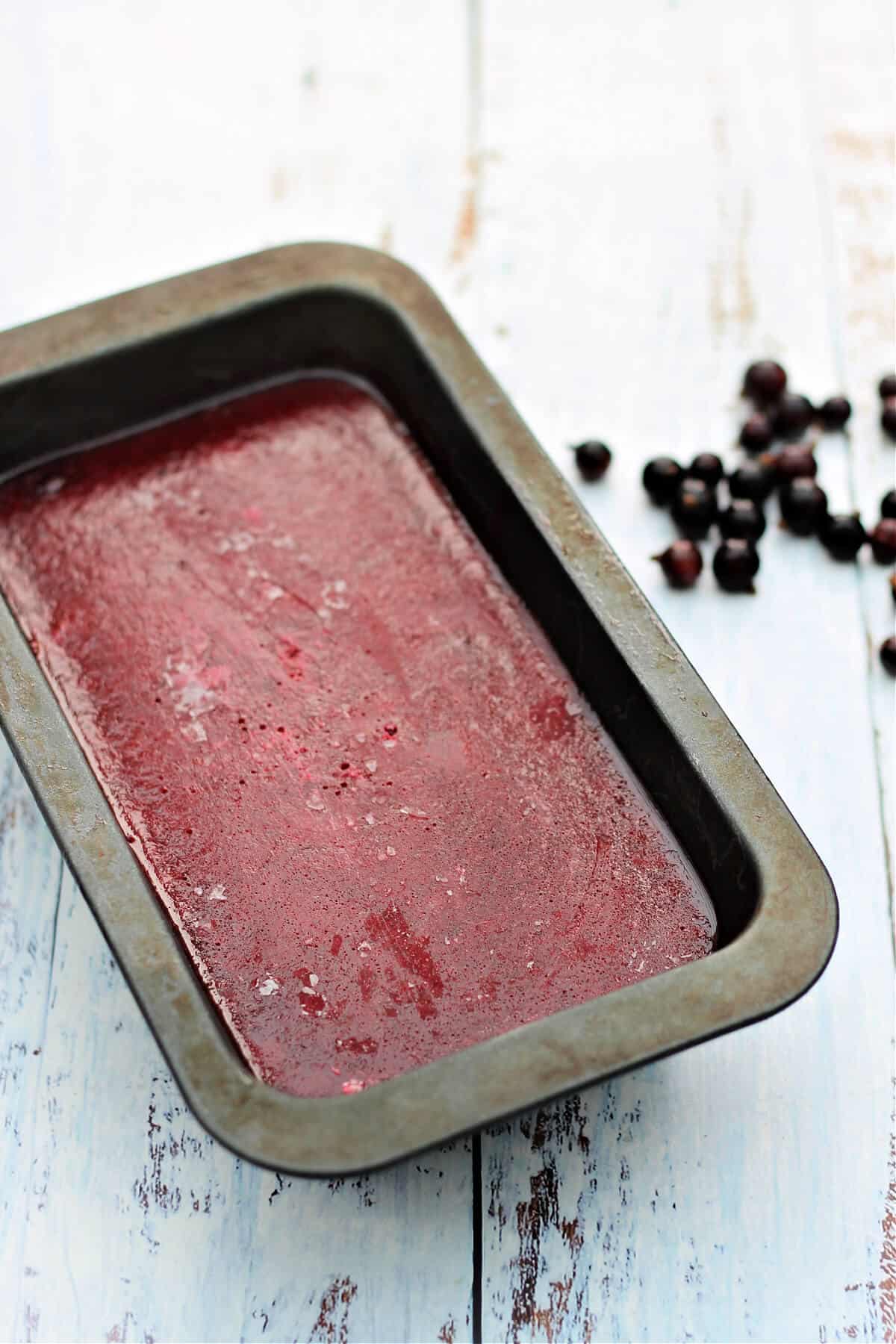 Frozen blackcurrant sorbet ready to serve from bread loaf tin.