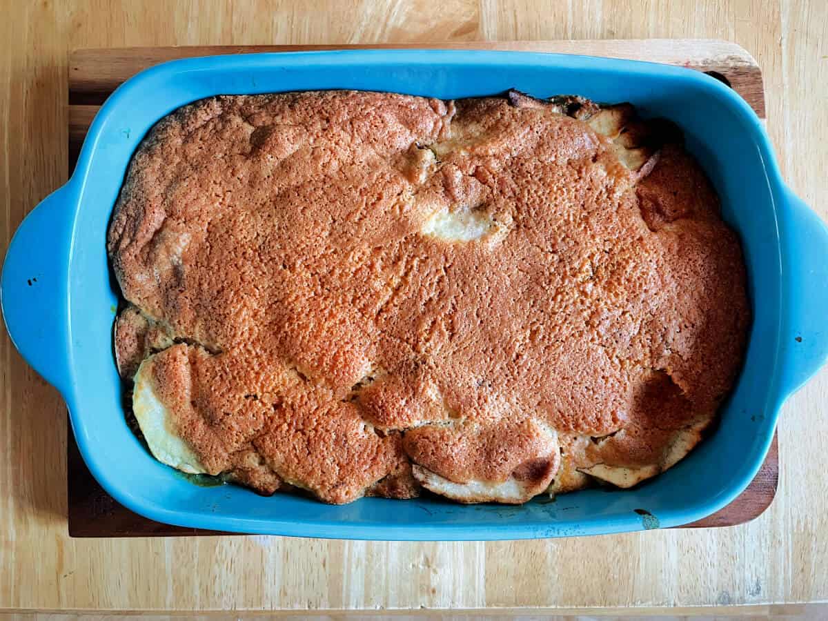 Cooked sponge pudding in blue baking dish.