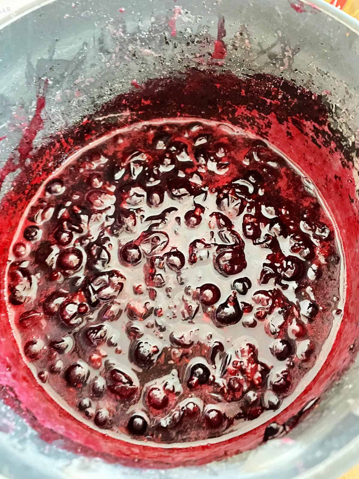 Pan of cooked blackcurrants.