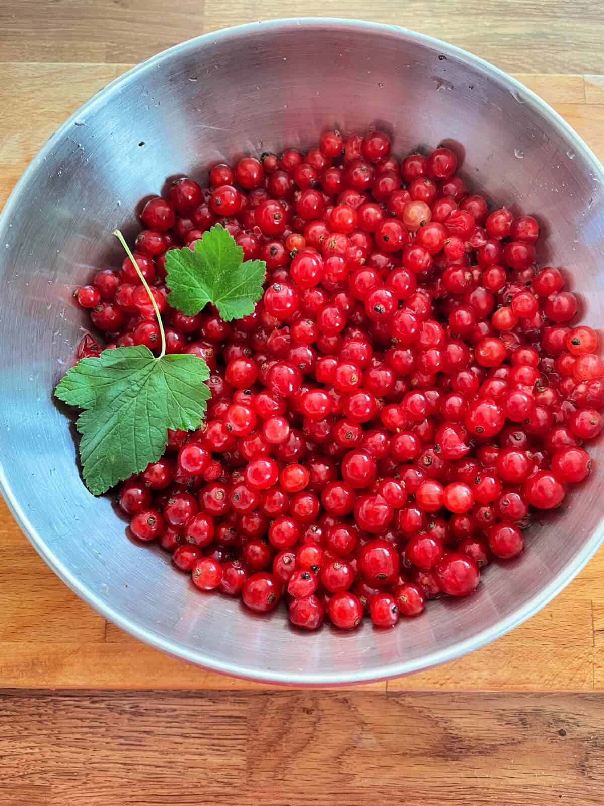 Redcurrants in a metal bowl.