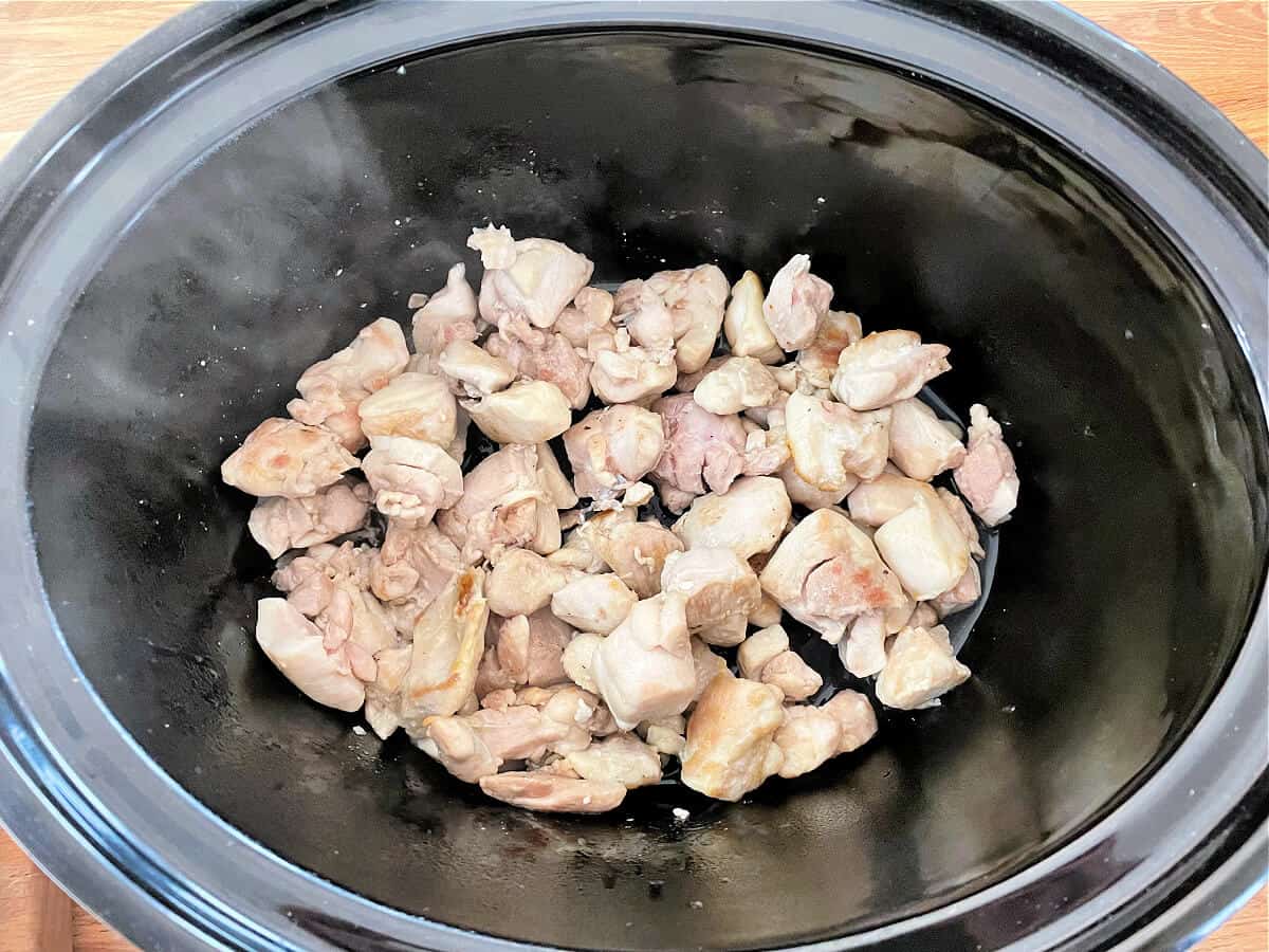 Chicken thigh chunks in slow cooker.