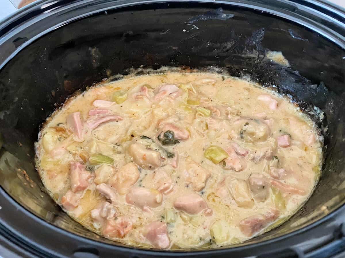 Cooked chicken pie filling in slow cooker.