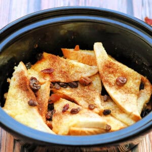 A baked bread and butter pudding in a slow cooker pot.