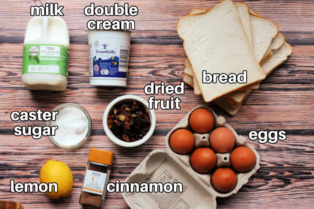 Ingredients for bread and butter pudding on wooden table, with text labels.