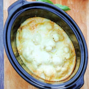 Cauliflower cheese in slow cooker pot.