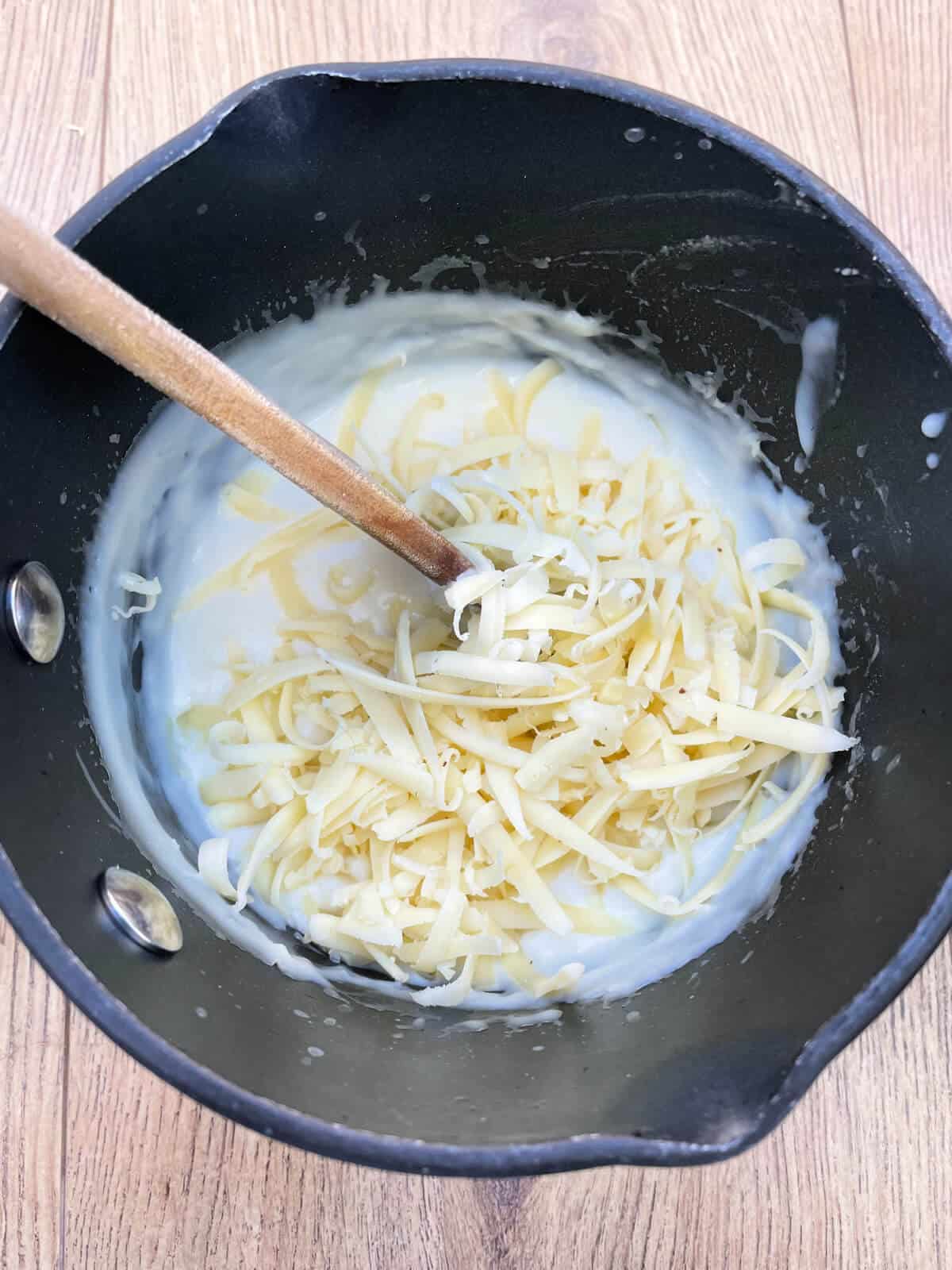 White sauce with grated cheese added, in saucepan.