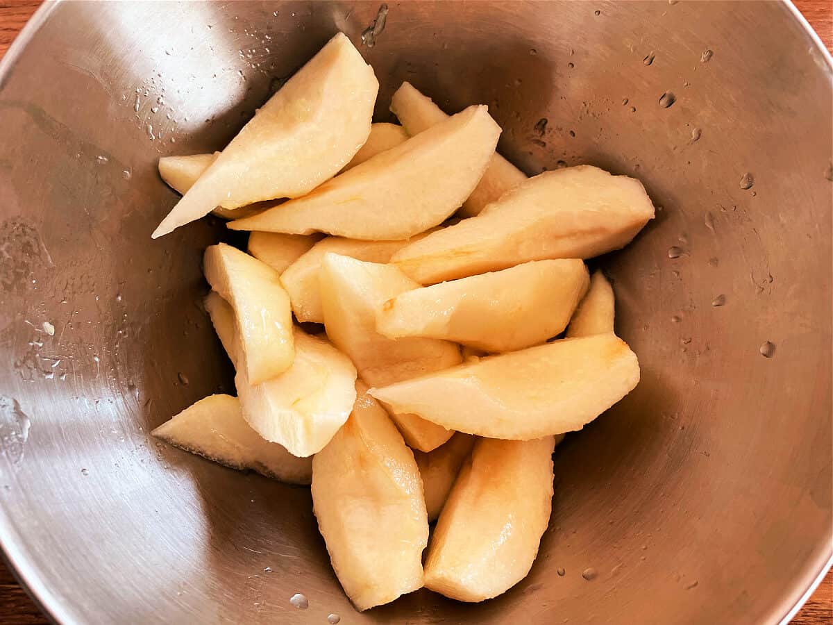 Sliced pears in a metal bowl.