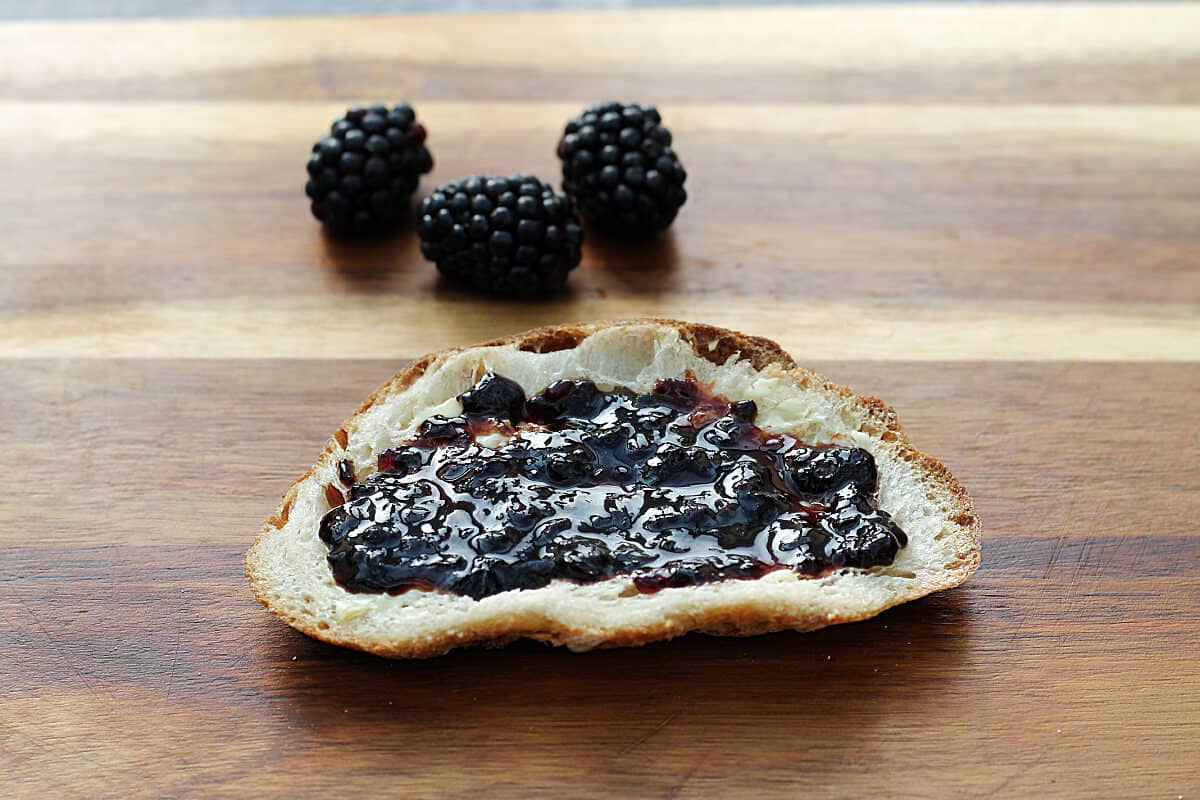 Blackberry jam on a slice of sourdough bread.