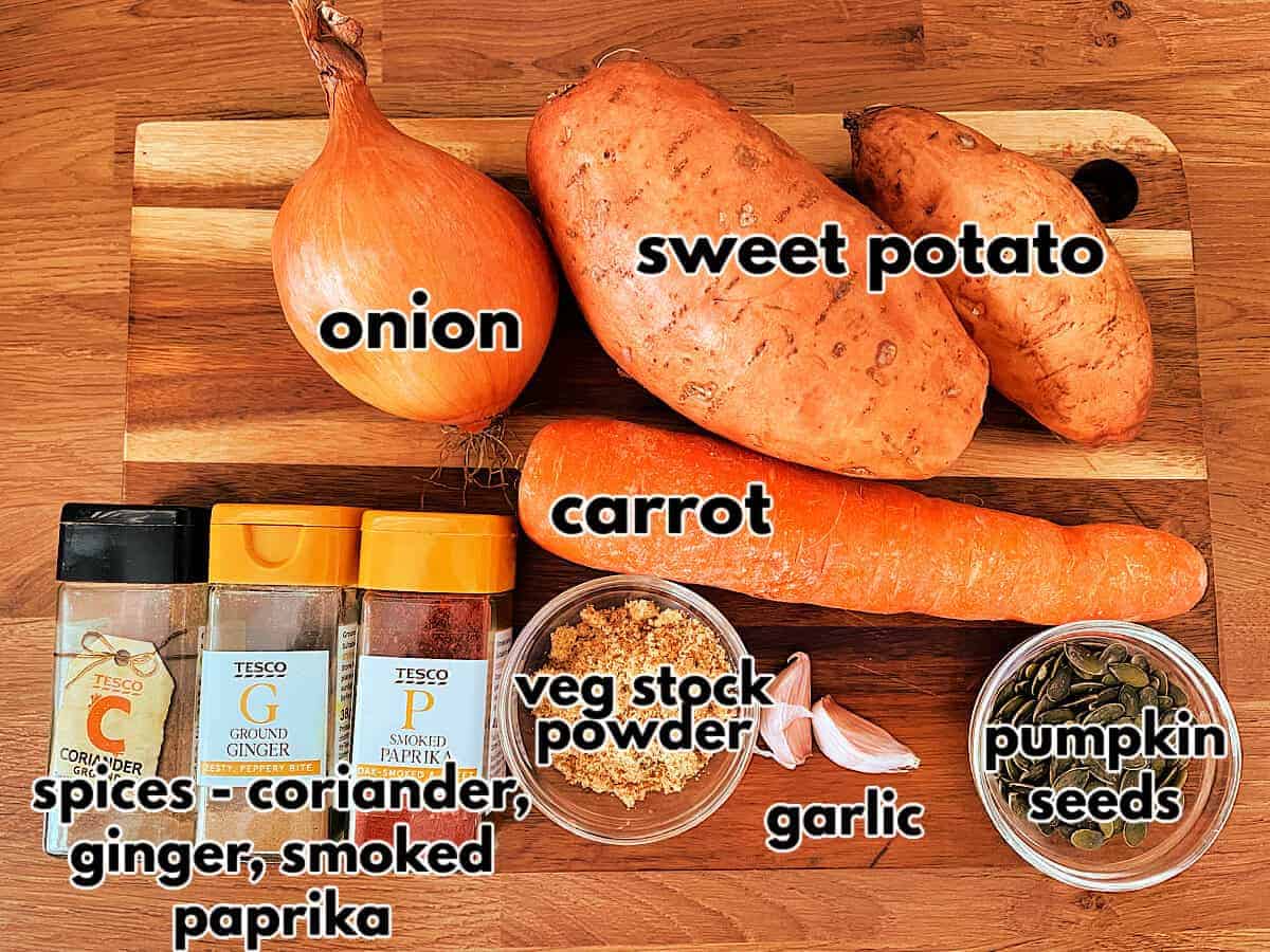 Labelled ingredients for sweet potato soup on a wooden chopping board.
