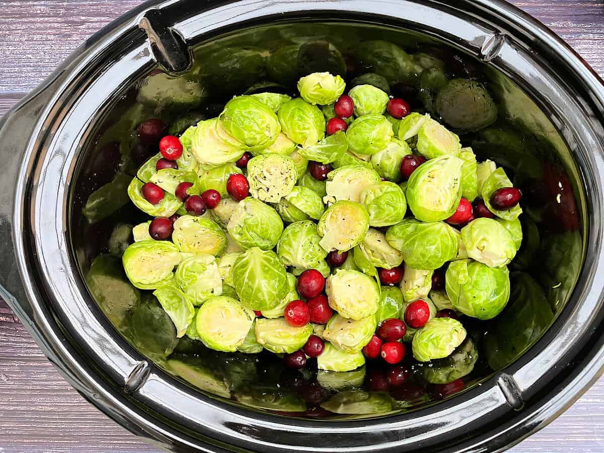 Brussels sprouts and cranberries in slow cooker pot.