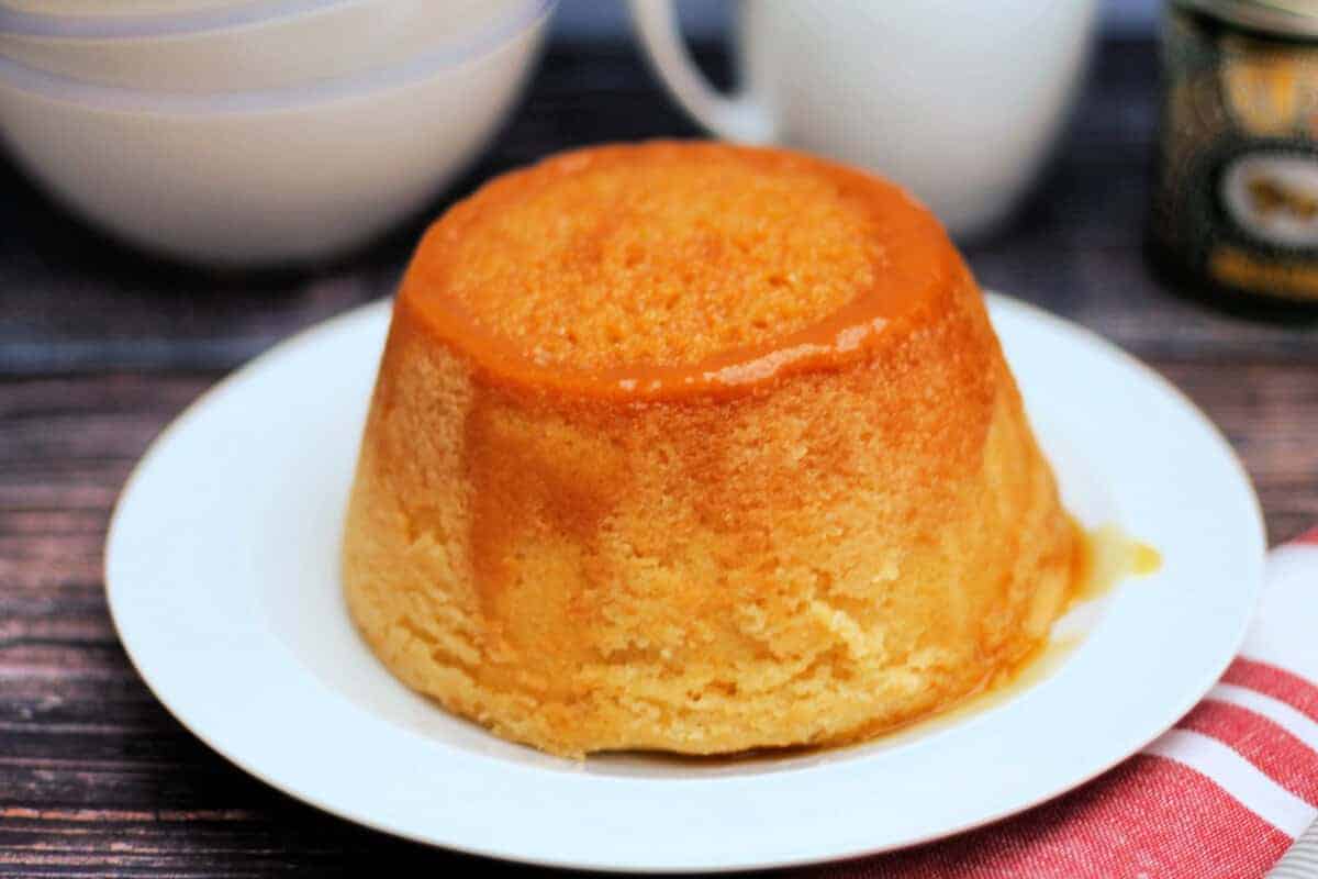 Steamed syrup sponge pudding on a white serving plate.