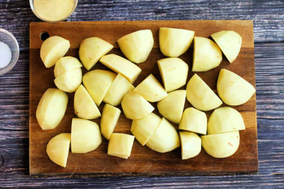 Chopped potatoes on wooden chopping board.
