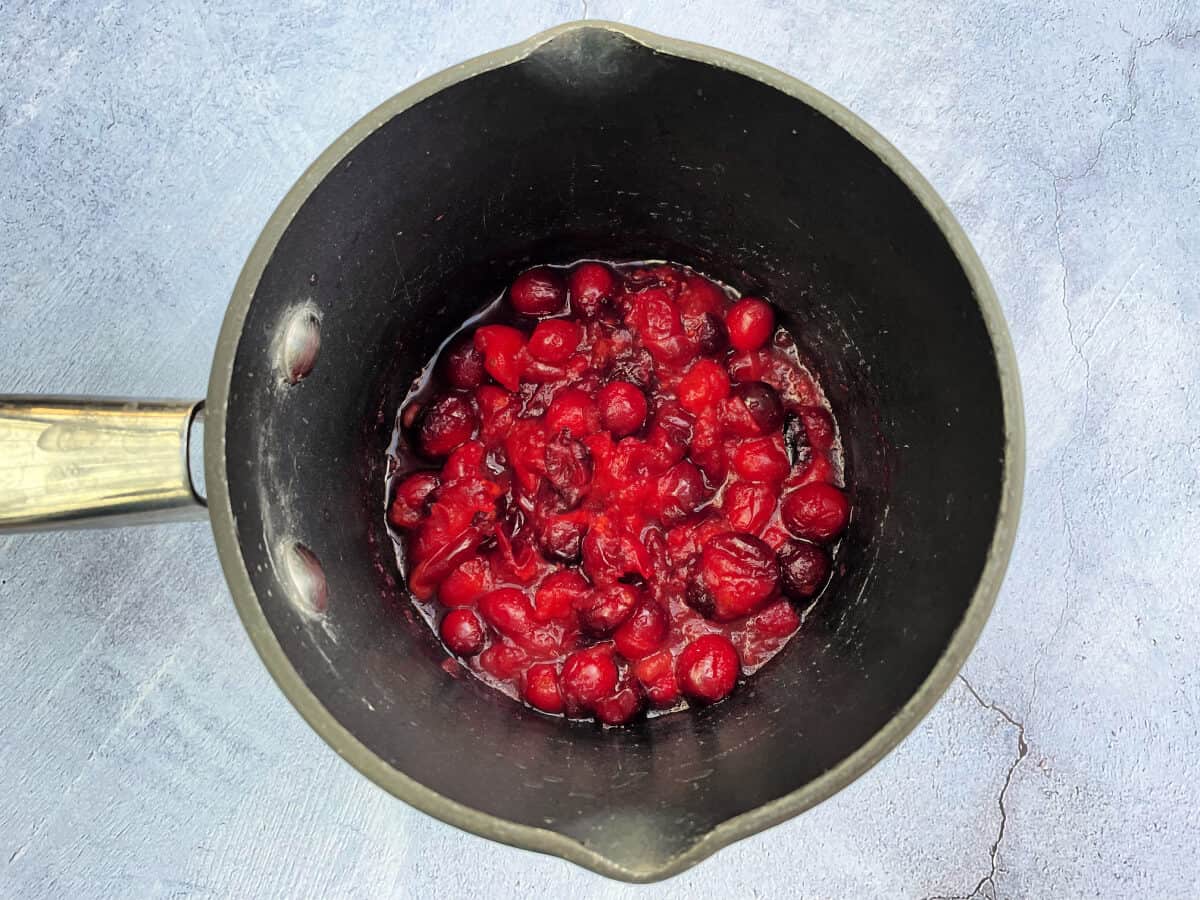 Small saucepan containing cooked cranberries.