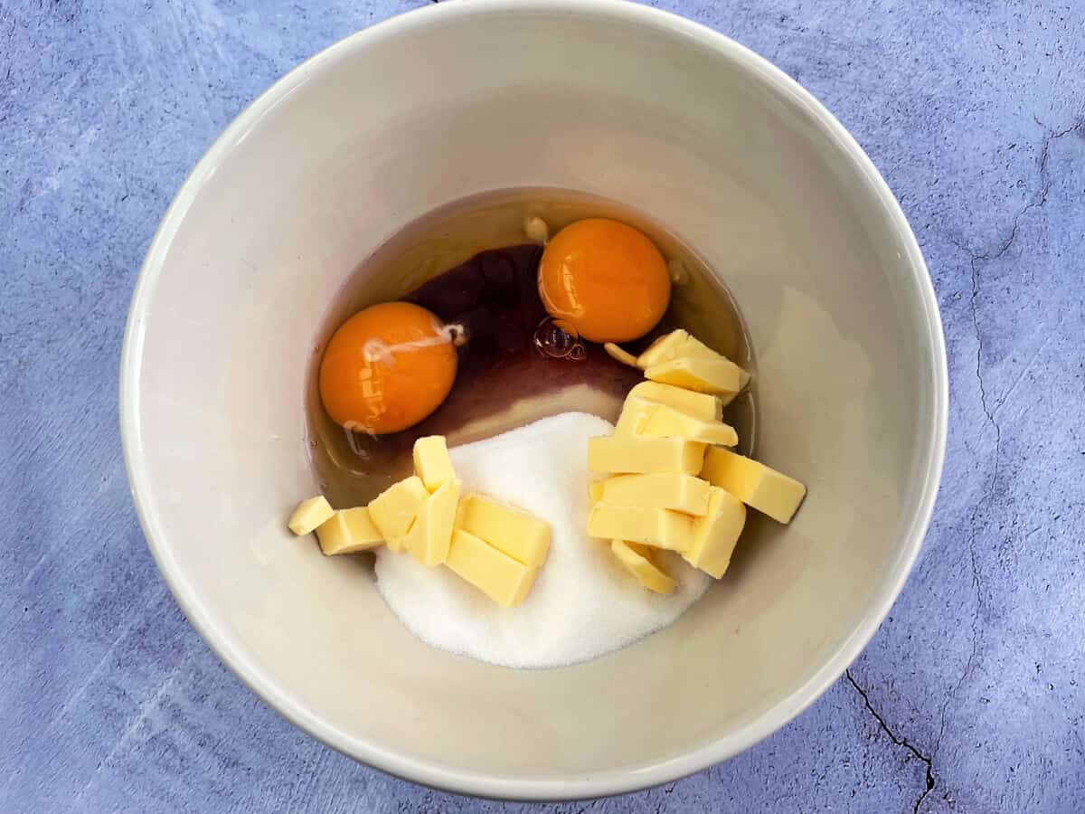 Bowl of cranberry puree, sugar, cubed butter and eggs.
