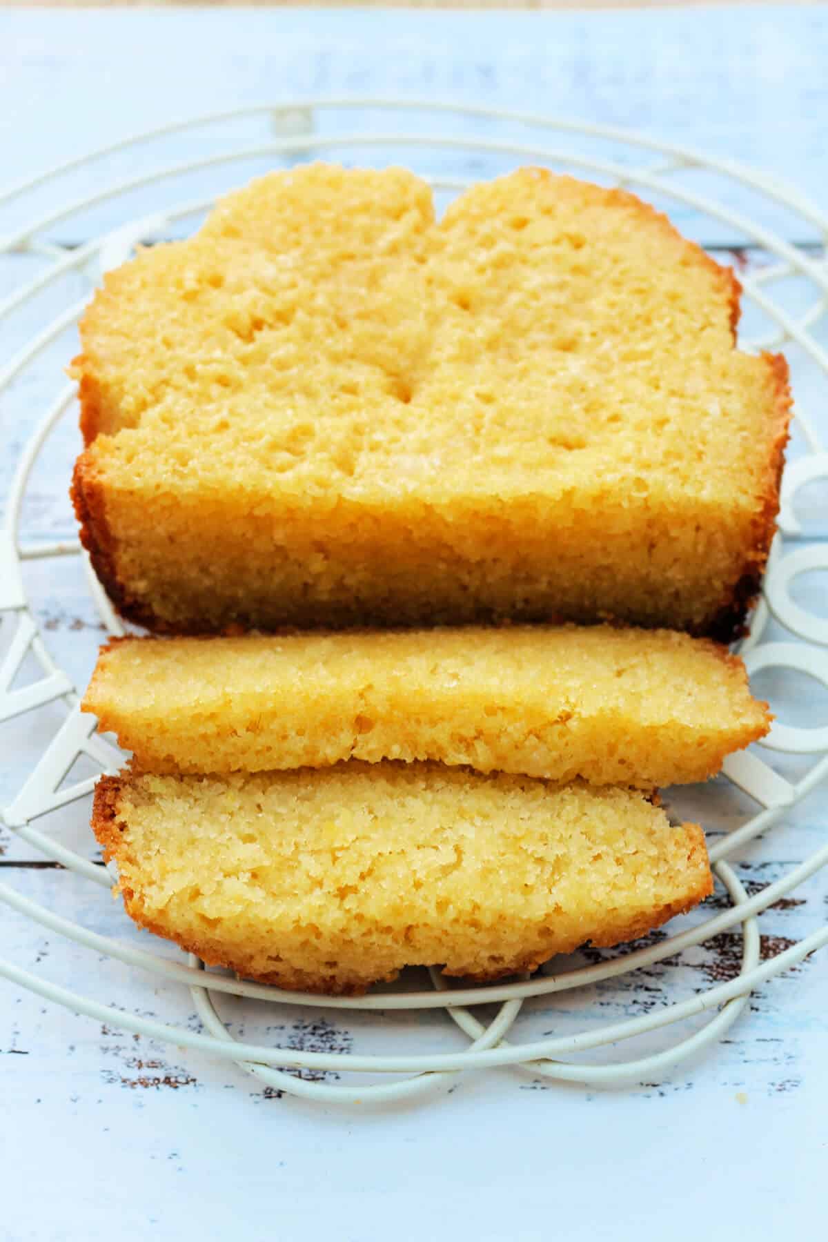 Lemon cake on a cooling rack, sliced.